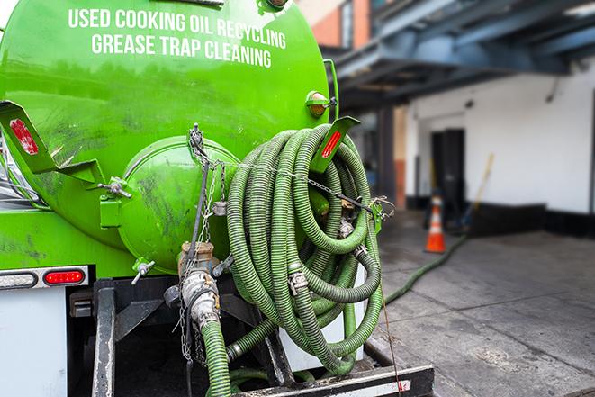 a technician pumping a grease trap in a commercial building in Lisle, IL